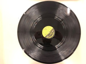 A glass lacquer disc from the 1940s with a yellow label in the center.