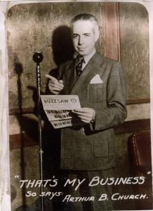 Publicity portrait of Arthur B. Church. Standing at angle near wall behind KMBC microphone stand and holding "Buzz Saw" newsletter dated Thursday May 7th. Printed note on front: "'That's My Business' / So says Arthur B. Church."